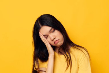 Sarı tişörtlü güzel esmer. Başında hoşnutsuz sarı bir zemin var. Değiştirilmemiş.