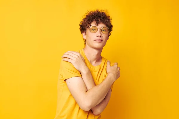 Portré egy fiatal göndör férfi visel elegáns szemüveg sárga póló pózol Életmód változatlan — Stock Fotó
