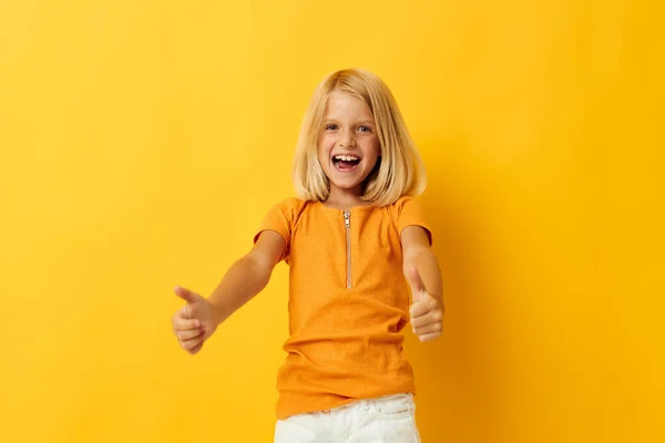 小さな女の子でA黄色tシャツ笑顔ポーズスタジオ子供時代のライフスタイル変更なし — ストック写真