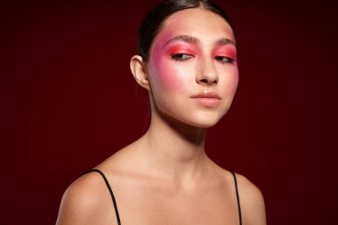 Seksi esmer kadın, el hareketleriyle lüks kozmetik ürünleri yapıyor.