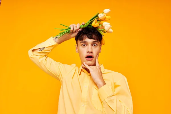 Mladý muž s módní účes ve žlutých košilích s květy žluté pozadí beze změny — Stock fotografie