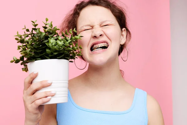 Chica divertida sosteniendo una olla con una flor estilo de vida inalterado — Foto de Stock