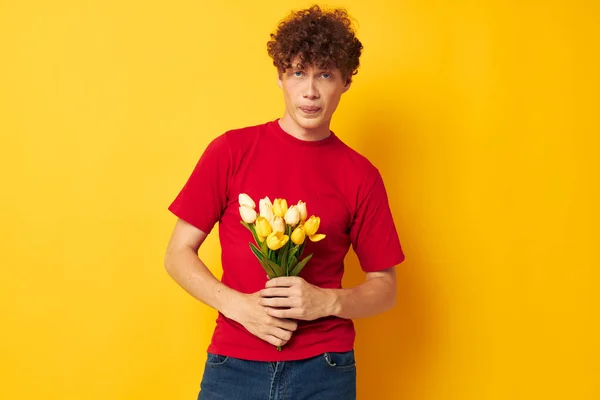 Портрет молодого кучерявого чоловіка в червоній футболці букет квітів святковий подарунок монохромний знімок — стокове фото