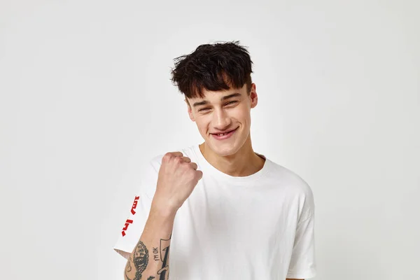 Un giovane uomo moderno stile giovanile bianco t-shirt tatuaggio sul braccio Stile di vita inalterato — Foto Stock