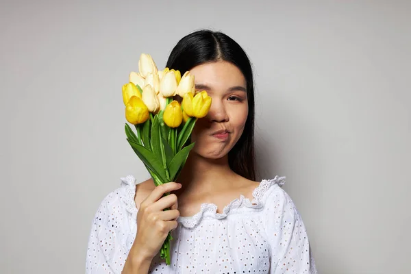 Okouzlující mladá asijská žena romantika kytice květin v blízkosti obličeje studio model beze změny — Stock fotografie