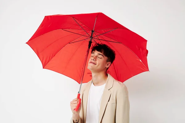 ファッションライトの背景を変えることなく傘を差した若者の肖像画 — ストック写真