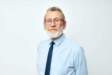 İş elbisesi içinde gri sakallı yaşlı adam.