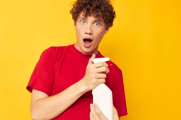 Guy with red curly hair in a red t-shirt detergents in hands posing Lifestyle unaltered — Fotografia de Stock