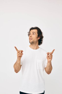 Beyaz tişörtlü, çekici bir adam. Görüntü arkaplanı kırpılmış.