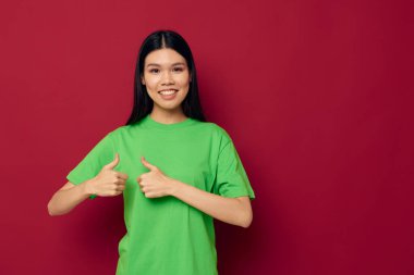 Asyalı güzel genç kadın portresi. Yeşil tişört jestleri.