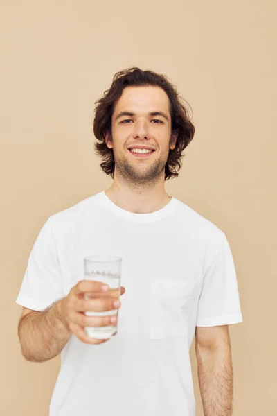迷人的男人透明的水杯健康米色背景 — 图库照片