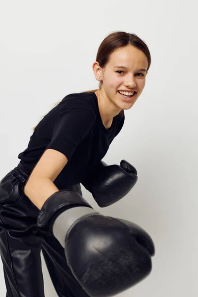 Atletická žena v boxerských rukavicích v černých kalhotách a tričku izolované pozadí — Stock fotografie