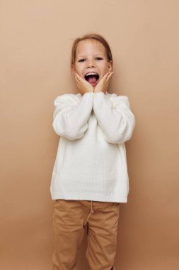 Sevimli kız neşesi Duyguları poz verme moda bej arka plan