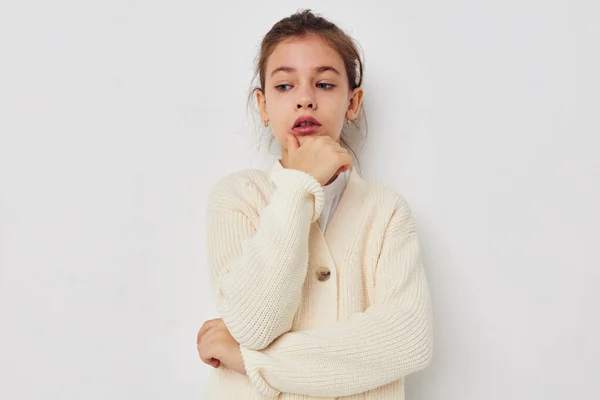 Маленька дівчинка позує на світлому фоні білого светра — стокове фото