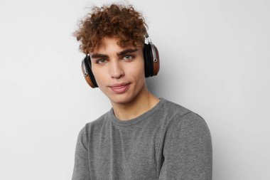 Kulaklıkla müzik dinleyen yakışıklı genç bir adam. Duyguları izole edilmiş.