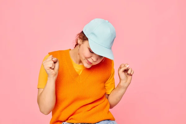 Vacker kvinna i en orange tröja i blå mössor hand gest beskärd vy oförändrad — Stockfoto