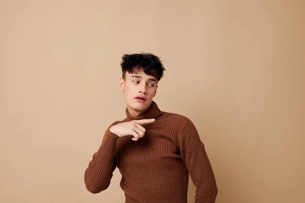 En ung man brun polotröja poserar mode ljus bakgrund oförändrad — Stockfoto