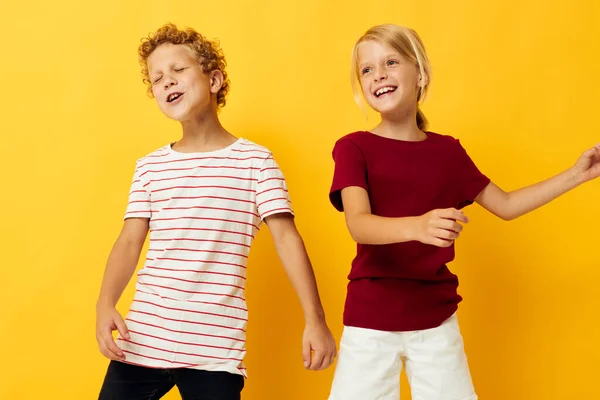 Malé děti mazlení módní dětství zábavy na barevném pozadí — Stock fotografie