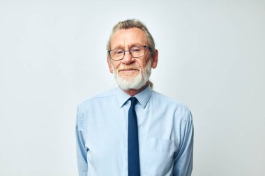 İş elbisesi içinde gri sakallı yaşlı adam.