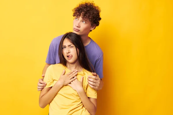 Portret van een man en een vrouw in kleurrijke t-shirts poseren vriendschap leuk geel achtergrond ongewijzigd — Stockfoto