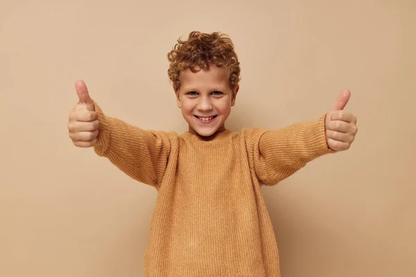 Roztomilý chlapeček v béžovém svetru pózuje zábavné dětství beze změny — Stock fotografie