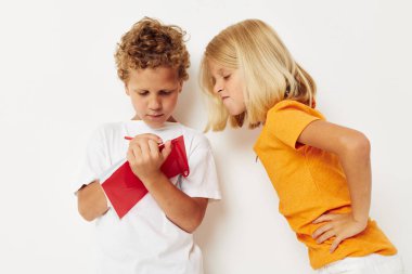 Renkli tişörtlerle gezen sevimli anaokulu çocukları. Not defteri rengi değiştirilmemiş.