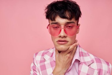 Yakışıklı adam pembe gözlüklü, kareli ceket modasında. Yaşam tarzını değiştirmemiş.