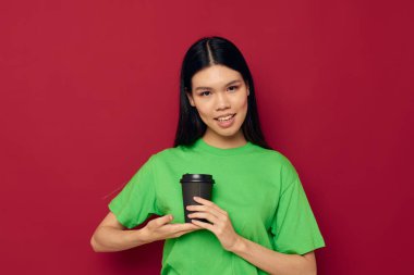 Asyalı kadın yeşil tişörtlü, tek kullanımlık siyah gözlükle poz veriyor. Stüdyo modeli değiştirilmemiş.