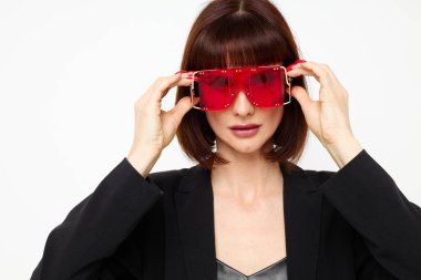 Kırmızılı güzel bir kadın şık gözlüklü, deri ceketli, siyah ceketli, hayat tarzını değiştirmemiş.