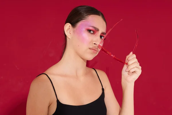 Sexy morena mujer en gafas de color rosa maquillaje emociones cosméticos aislado fondo inalterado — Foto de Stock