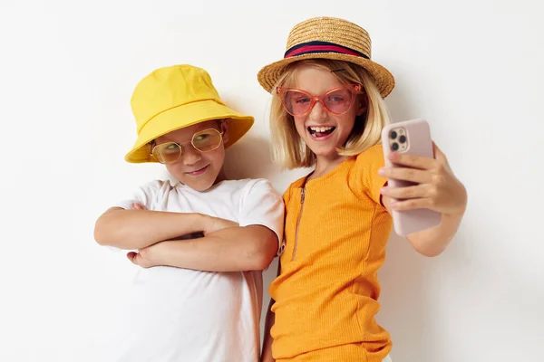 어릴 때 패션 사진을 찍는 전화 모자를 쓰고 있는 소년 소녀들 — 스톡 사진