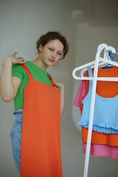Ładna kobieta próbuje na ubrania szafa Młodzież styl izolowane tła bez zmian — Zdjęcie stockowe