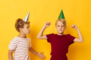 Erkek ve kız gülümsüyor ve renkli arka planda günlük kıyafetlerle poz veriyorlar.