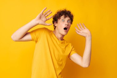 Sevimli kızıl saçlı çocuk. Gençlik tarzı stüdyo resmi. Sarı arka planı değiştirilmemiş.