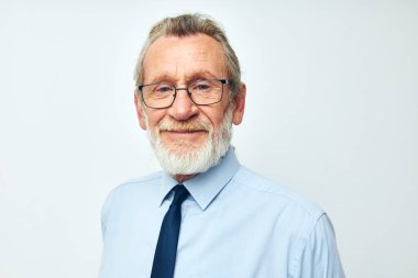 Kıdemli, gri saçlı, kravatlı, arka planda fotokopi kağıdı olan bir adam.