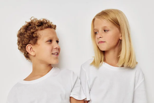 Niño y niña con camisetas blancas están de pie junto a Lifestyle inalterados — Foto de Stock
