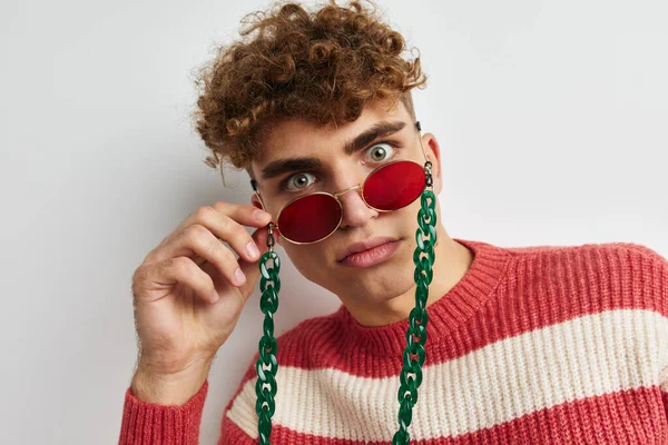 Muž v pruhovaném svetru stylové brýle módní světlo pozadí — Stock fotografie