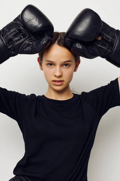 身穿黑色运动服的年轻女子拳击手套的生活方式保持不变 — 图库照片