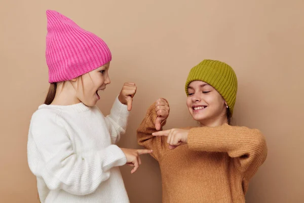 Dvě legrační dívky objímání pózování barevné klobouky — Stock fotografie