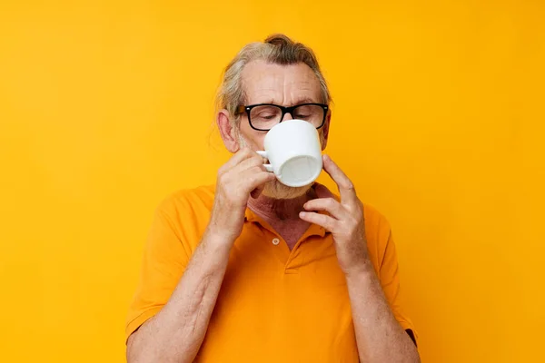 Photo of retired old man in a yellow t-shirt white mug monochrome shot — Stock Photo, Image