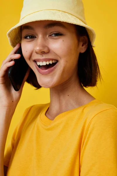 Αισιόδοξη νεαρή γυναίκα σε ένα κίτρινο καπέλο Νεανικό στυλ casual μιλώντας στο τηλέφωνο Lifestyle αμετάβλητη — Φωτογραφία Αρχείου