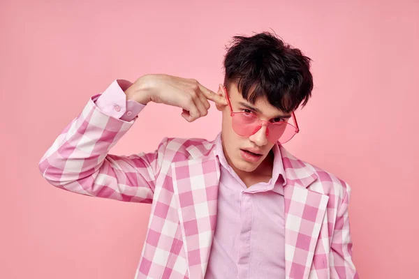 Portré egy fiatal férfi rózsaszín szemüveg kockás kabát divat pózol modell stúdió — Stock Fotó