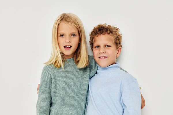 2人の子供の写真楽しい光の背景のためにポーズをとる多色のセーター — ストック写真