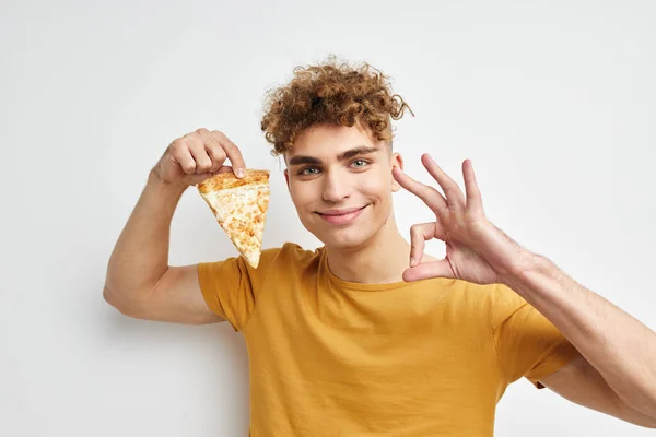 Дивний хлопець в жовтій футболці, що їсть піцу Стиль життя незмінний — стокове фото
