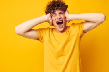 Sevimli, kızıl saçlı, sarı tişörtlü, el hareketleriyle sarı arka planı değiştirilmemiş.