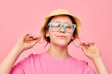 Panama şapkalı ve gözlüklü genç bir kadının portresi.