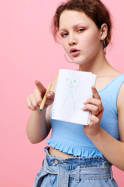 Portrait d'une femme dans un T-shirt bleu avec un bloc-notes rouge et un stylo d'émotions fond isolé inaltéré — Photo