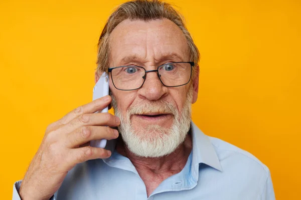 Stock image elderly man talking on the phone posing close-up cropped view