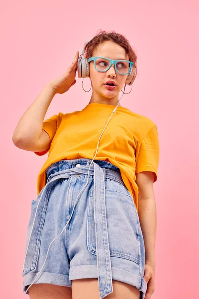Csinos nő visel kék szemüveg hallgat zenét fülhallgató elszigetelt hátterek változatlan — Stock Fotó