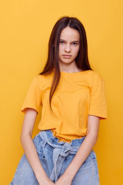 İyimser genç kadın modası sarı tişörtlü kot şortlu izole edilmiş arka plan